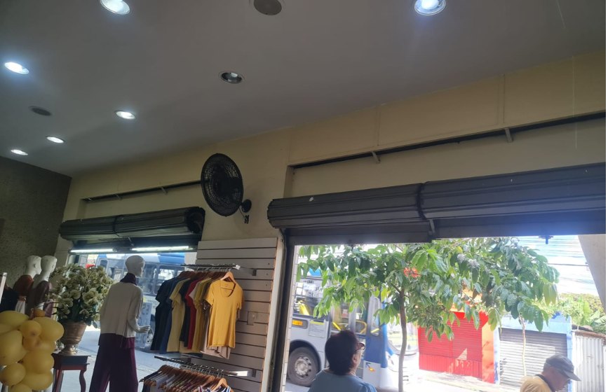 Interior de loja com rolo da porta de enrolar aparente antes do fechamento