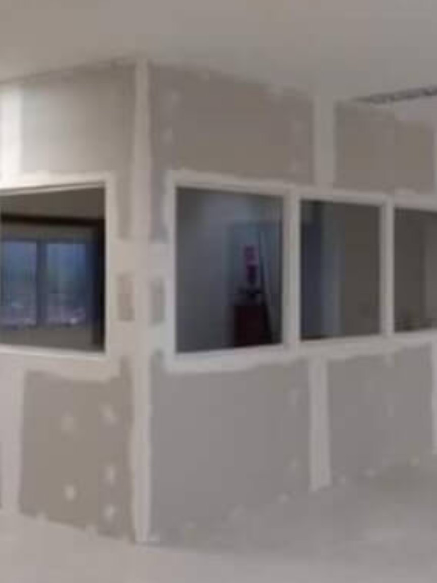 Divisórias em drywall com vãos de visores em ambiente comercial
