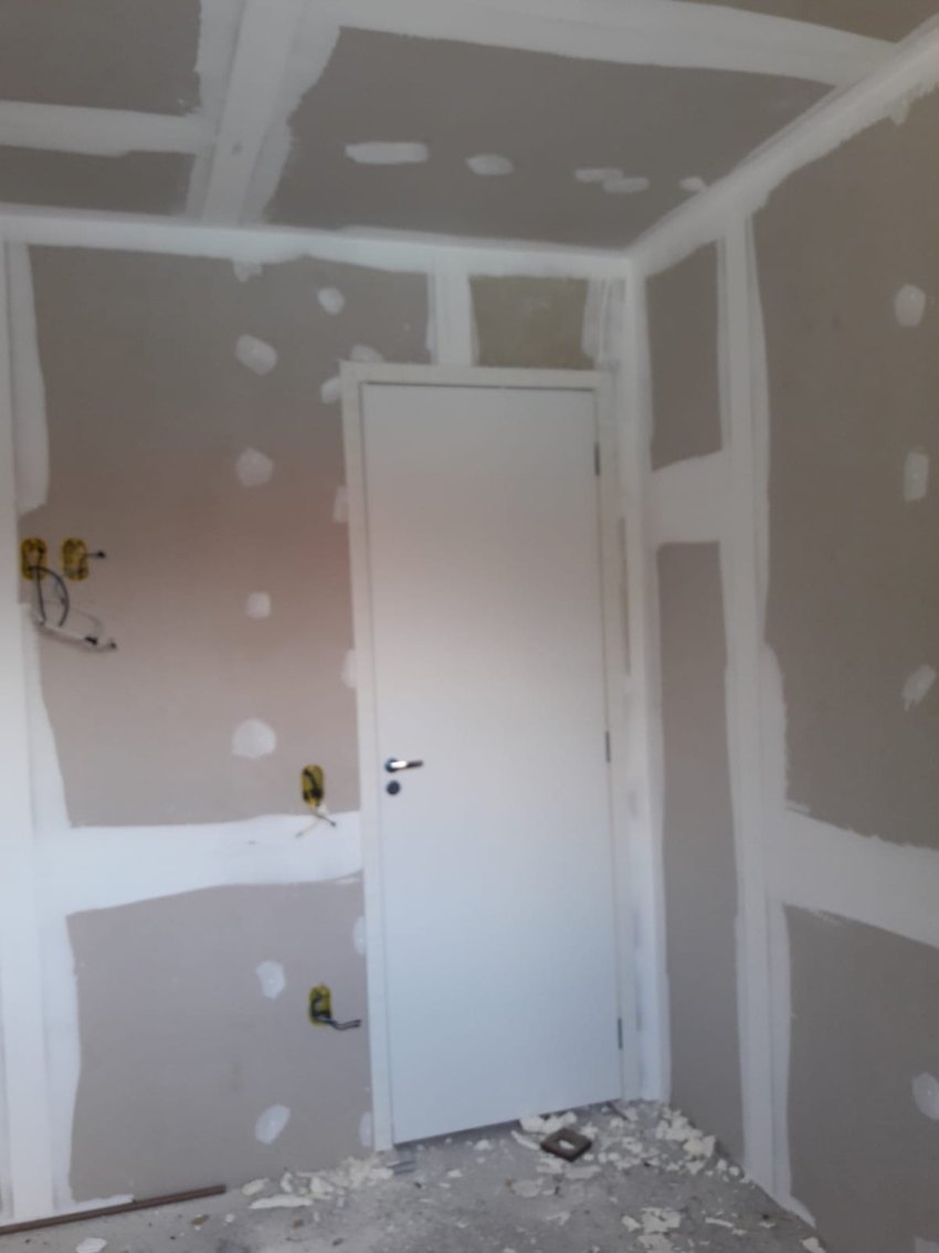 Porta de abrir instalada em ambiente com paredes em drywall